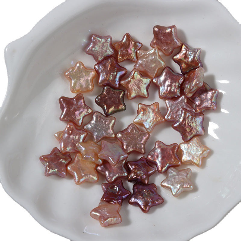 Star-shaped baroque freshwater pearls in golden and purple tones on a white ceramic plate