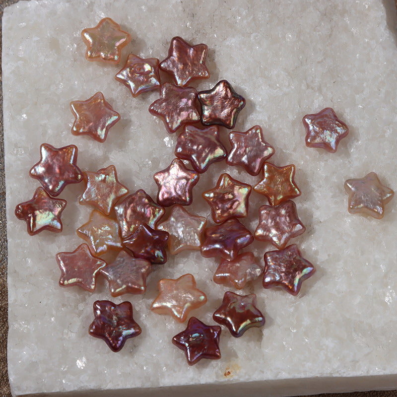Mixed natural baroque star pearls arranged on a textured white stone