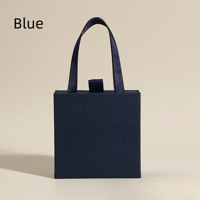 Blue textured jewelry box with navy ribbon handle