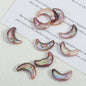 Close-up of colorful moon-shaped pearls on white paper